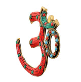 Brass OM wall hanging, angled view with red mosaic tiles, teal details, and circular gem frame