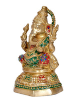 Brass Ganesh statue side view, raised hand gestures and jeweled green attire