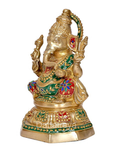 Brass Ganesh statue side view, raised hand gestures and jeweled green attire