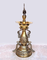 Brass peacock diya stand with three-tier bowls, ornate peacock figure on top