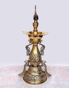 Brass peacock diya stand with three-tier bowls, ornate peacock figure on top