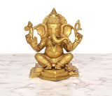 Brass sitting Lord Ganesha figurine with raised hands, golden finish, seated