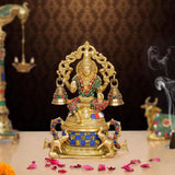 Brass Lakshmi sitting statue with ornate crown, raised arms, bells, and multicolored details