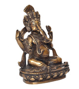 Seated Ganesha figurine with raised hands, side profile, lotus pedestal, brass tone