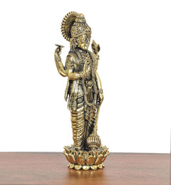 Brass Lord Vishnu idol angled view, one hand raised, beaded ornaments and lotus base