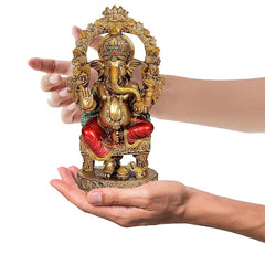 Resin Ganesha idol, held in hands for scale, red dhoti, ornate gold crown