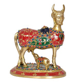 Brass Kamdhenu cow and calf figurine, red and green jewel-like decorations, raised head