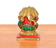 Close-up of brass Panchmukhi Ganesha sitting murti with red and green attire
