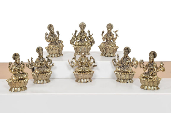 Brass Lakshmi idol set of 8, group view of seated figures with raised hands