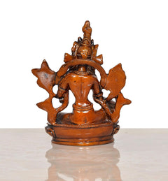 Back view of brass Tara Devi statue with four arms and spiked halo, seated on pedestal; 4 inch