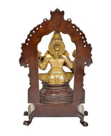 Back view of brass seated Saraswati idol with domed arch and textured detailing