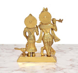 Brass Radha Krishna idol from rear angle; ornate details and engraved base.