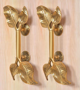 Golden brass twin-leaf door handle pair, leaf-shaped grips and round latch rosettes
