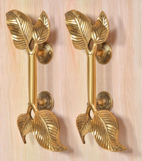 Golden brass twin-leaf door handle pair, leaf-shaped grips and round latch rosettes