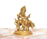Golden brass Krishna playing flute statue riding a cow, detailed face and ornaments