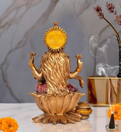 Lakshmi resin statue back view, golden headpiece and flowing hair, seated on lotus petals