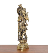 Brass Lord Krishna idol with flute, side view showing ornate base and patterned details