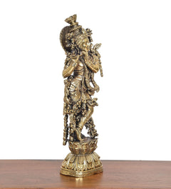 Brass Lord Krishna idol with flute, side view showing ornate base and patterned details