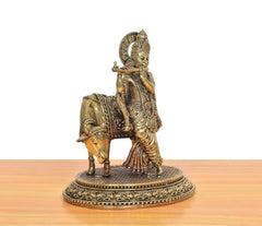 Brass Krishna on cow idol, side view with flute raised, detailed round base