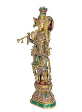 Brass Krishna statue side view holding flute, gold tones with colorful inlays