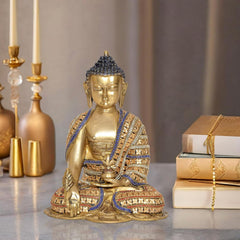 Brass meditating Buddha statue with blue-and-gold beaded robe, seated on round base