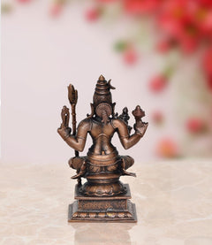 Rajarajeshvari statue back view, seated deity with crown and staffs, copper tone.