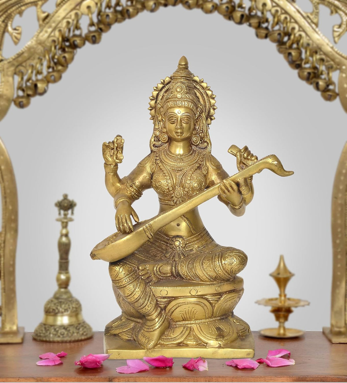 Brass Saraswati idol, seated playing veena with ornate headdress and jewelry