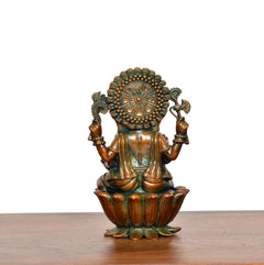 Back view of Lord Ganesha brass statue with decorative halo and painted detail