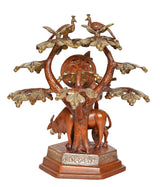 Krishna-Statue mit Flöte am Baum, zwei Vögel oben, große Blattornamente