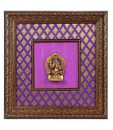 Brass Lord Ganesha idol centered in ornate wooden frame, purple cloth backdrop