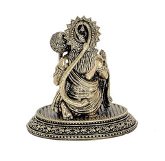 Back/angled view of brass Hanuman sitting statue idol, ornate headpiece and robe