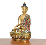 Brass-tone meditating Buddha statue from side angle with jeweled shoulder drape