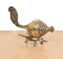 Brass shankh conch with ornate detailing and curved extended tail on stand