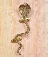 Ornate brass snake door handle with two screws on round golden plates