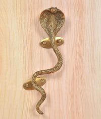 Ornate brass snake door handle with two screws on round golden plates