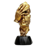 Gold polyresin human face ornament, raised hand, black pedestal base, front angled view