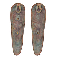 Bronze-green backs of tribal face plaques, two hanging loops at the top