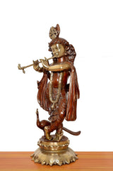 Side view of Krishna brass idol playing flute, draped robe and detailed pedestal
