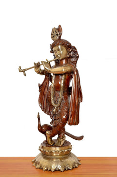Side view of Krishna brass idol playing flute, draped robe and detailed pedestal