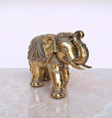 Gold-tone brass elephant figurine, side view with engraved saddle and decorative details