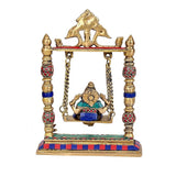 Back view of brass Ganesha swing idol with gold back panel and blue base