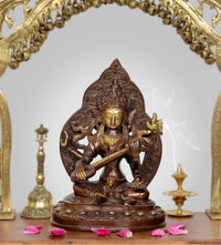 Brass Tara Devi statue, seated lotus pose holding a staff with ornate halo