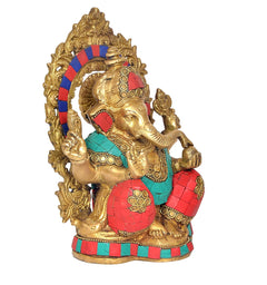 Brass Ganesha idol in profile, gold halo behind head, red hands and teal torso