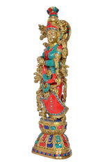 Brass Radha idol statue from side view, red lehenga with teal trim and gold halo