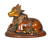 Seated Nandi brass bull statue, side view with painted jewelry pattern and carved base