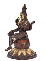 Saraswati statue with veena and blessing hand, seated on a lotus base.