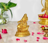 Gold Ganesha idol statue, seated with ornate details and circular base