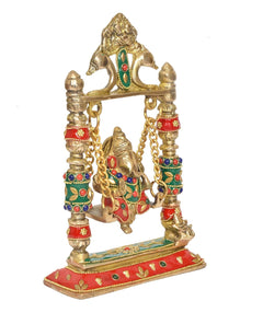 Brass Ganesha swing jhula with golden chains, red base, and green accents