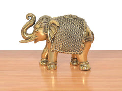 Brass elephant figurine with trunk raised and studded decorative armor, small tabletop size
