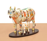Resin cow and calf statue, white with orange hand symbols and colorful character illustrations